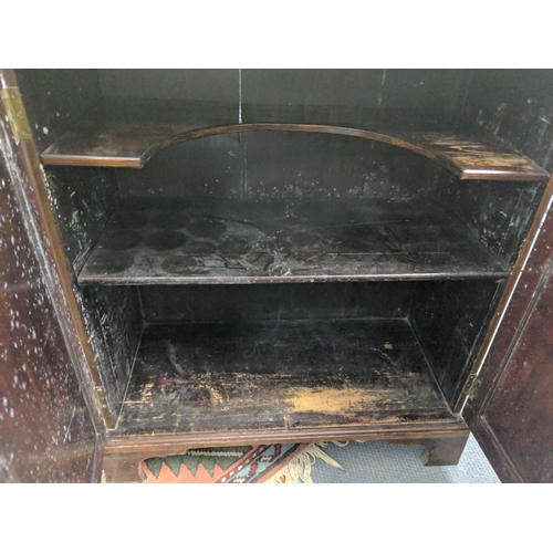 60 - A late 19th/early 20th century flame mahogany cupboards with a pair of panelled doors revealing a sh... 