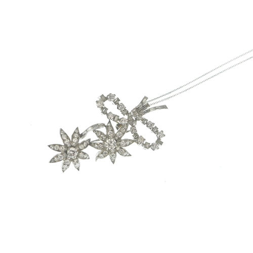 14 - A diamond white metal floral spray pendant on 9ct gold chain, the brooch-pendant modelled as a ribbo... 