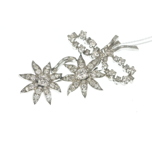 14 - A diamond white metal floral spray pendant on 9ct gold chain, the brooch-pendant modelled as a ribbo... 