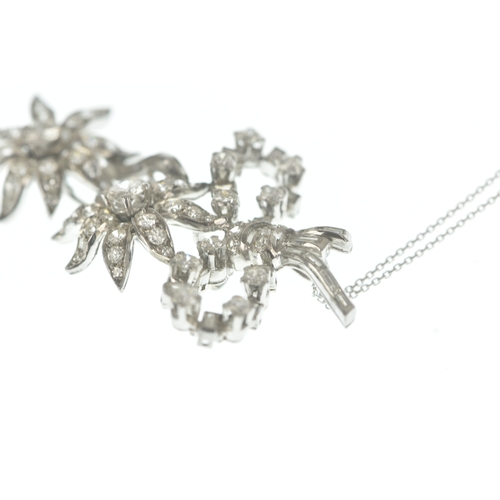 14 - A diamond white metal floral spray pendant on 9ct gold chain, the brooch-pendant modelled as a ribbo... 