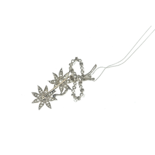 14 - A diamond white metal floral spray pendant on 9ct gold chain, the brooch-pendant modelled as a ribbo... 