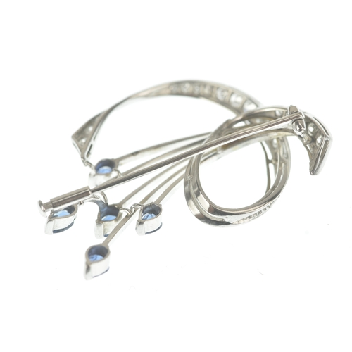 15 - A sapphire and diamond 18ct white gold brooch, of floral spray design set with pear-cut sapphires to... 