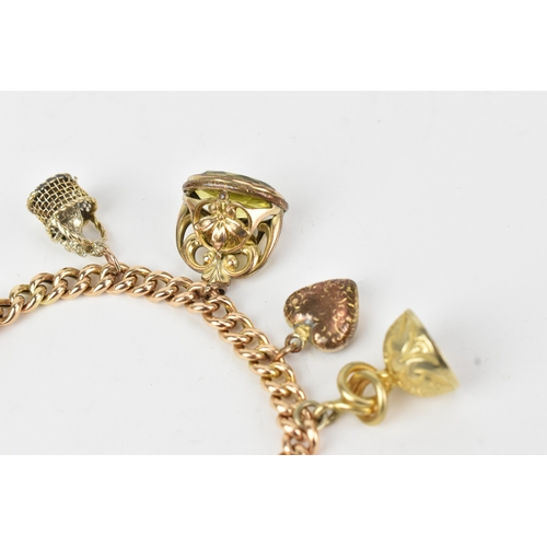 17 - A 9ct gold curb link bracelet,  fitted with a heart shaped catch and locket, a tassel, fob seals and... 