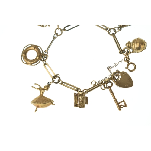 22 - A 9ct gold charm bracelet,  fitted with an assortment of charms including a key, boot, ballet dancer... 