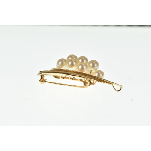 23 - A cultured pearl set 14ct gold spray brooch, designed as a stylised abstract foliate spray with text... 