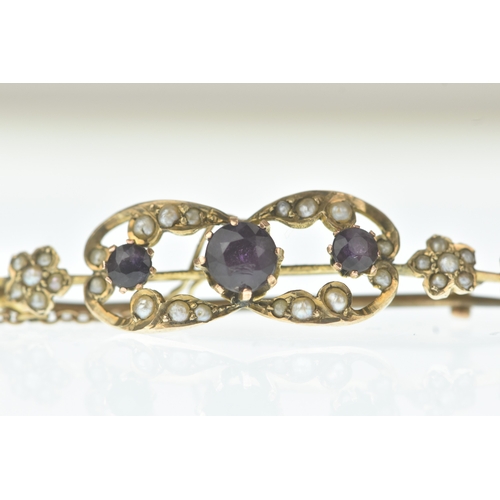 26 - An Edwardian seed pearl and amethyst 9ct gold bar brooch, the scrolling openwork panel set with thre... 