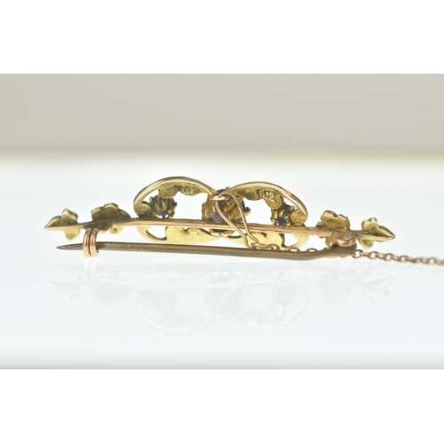 26 - An Edwardian seed pearl and amethyst 9ct gold bar brooch, the scrolling openwork panel set with thre... 