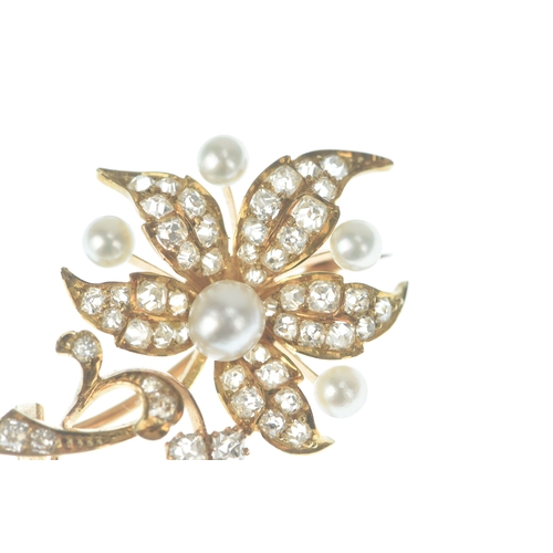 46 - A diamond and pearl 14ct gold floral brooch designed as a scrolling foliate spray set throughout wit... 