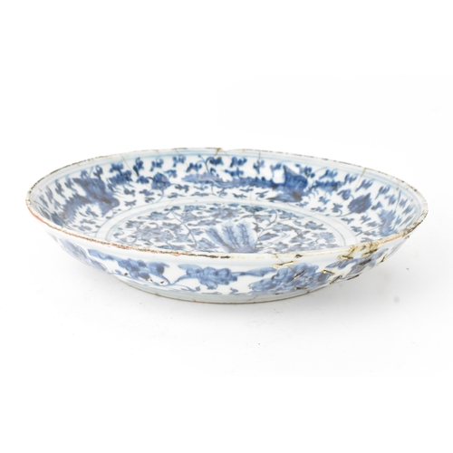 22 - A Chinese Ming dynasty blue and white charger, painted with a phoenix amidst scrolling peony and bir... 