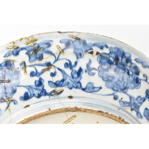 22 - A Chinese Ming dynasty blue and white charger, painted with a phoenix amidst scrolling peony and bir... 