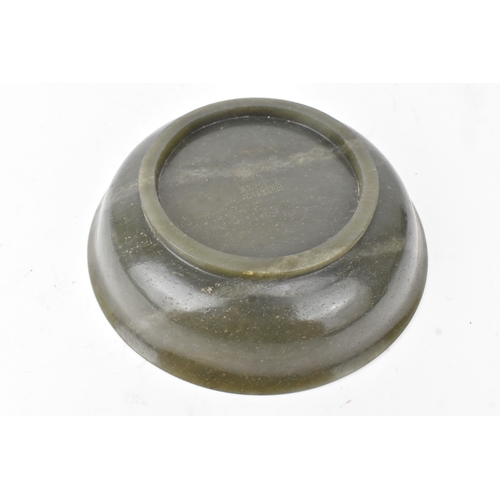 27 - A Chinese spinach green jade bowl, of circular shallow form with recessed footrim, the underside inc... 