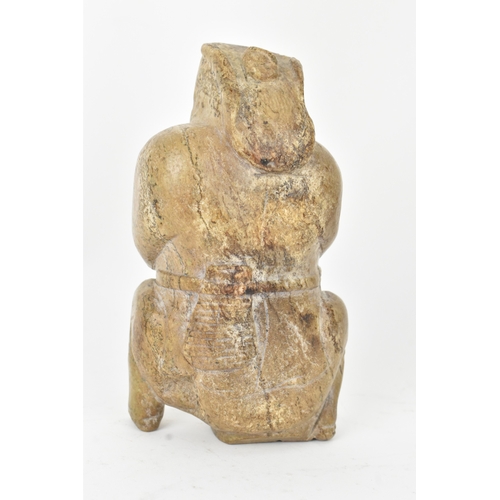28 - A Chinese carved hardstone figure and an archaistic hardstone blade-form carving, the figure modelle... 