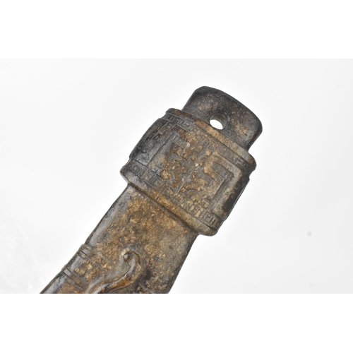 28 - A Chinese carved hardstone figure and an archaistic hardstone blade-form carving, the figure modelle... 