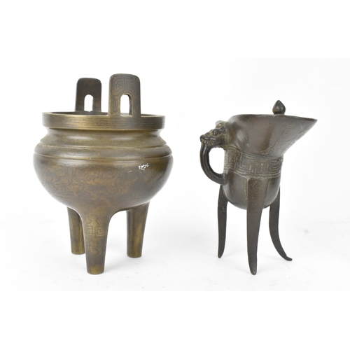 29 - A pair of Chinese bronze tripod vessels, comprising a ding with engraved decoration and an apocrypha... 