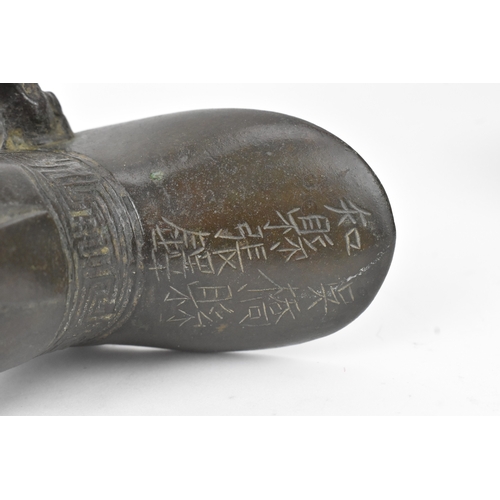 29 - A pair of Chinese bronze tripod vessels, comprising a ding with engraved decoration and an apocrypha... 