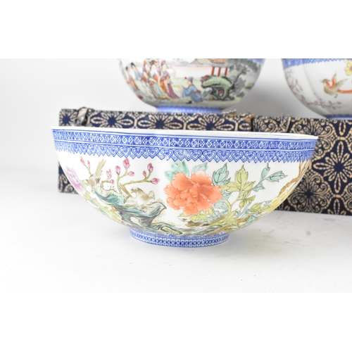 34 - A group of five Chinese famille rose egg shell porcelain bowls, with blue enamel borders, decorated ... 