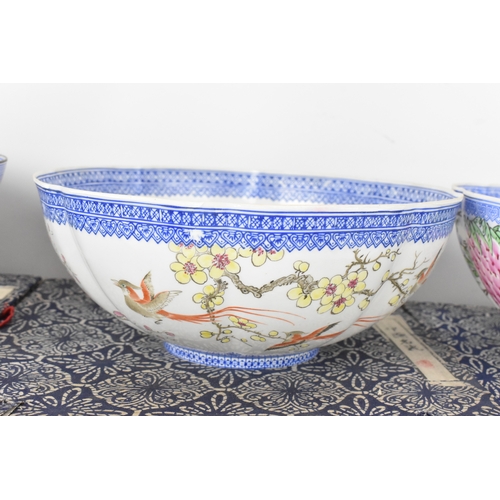 34 - A group of five Chinese famille rose egg shell porcelain bowls, with blue enamel borders, decorated ... 