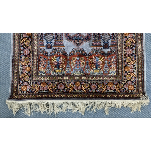 48 - A Persian part silk rug, with central mihrab design flanked by flowering columns, stylised vases, tr... 
