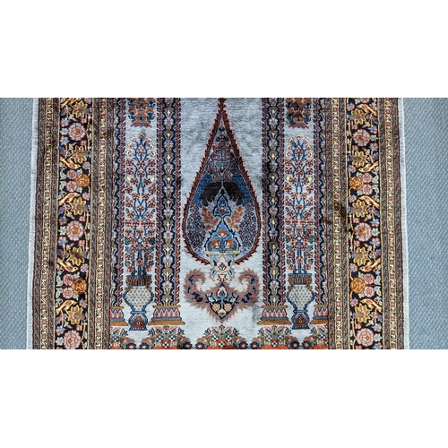 48 - A Persian part silk rug, with central mihrab design flanked by flowering columns, stylised vases, tr... 