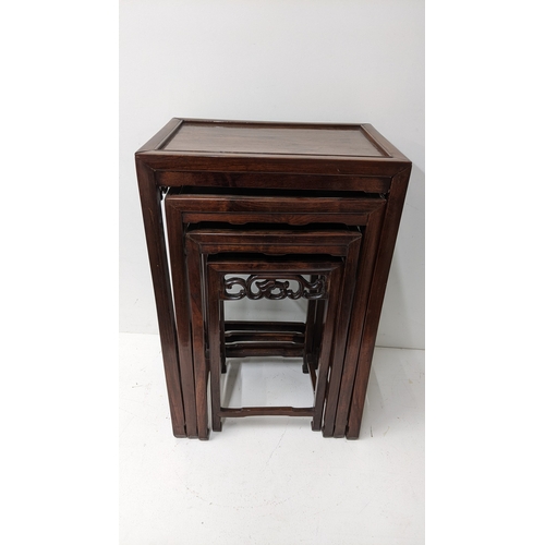 49 - A nest of four Chinese hardwood occasional tables, each rectangular top with moulded edge above a pi... 