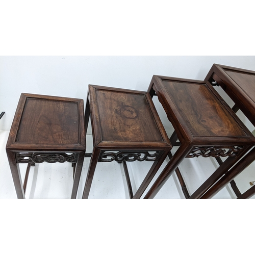 49 - A nest of four Chinese hardwood occasional tables, each rectangular top with moulded edge above a pi... 