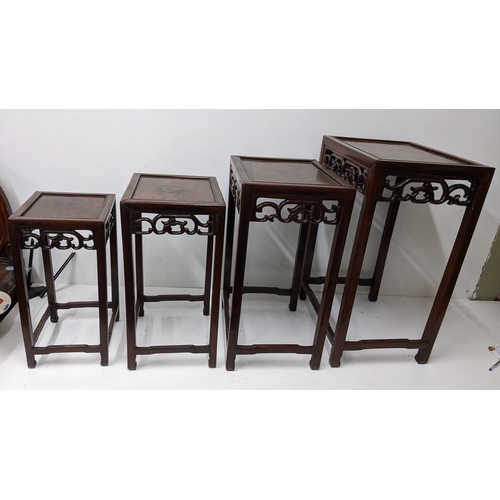 49 - A nest of four Chinese hardwood occasional tables, each rectangular top with moulded edge above a pi... 