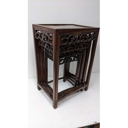 49 - A nest of four Chinese hardwood occasional tables, each rectangular top with moulded edge above a pi... 