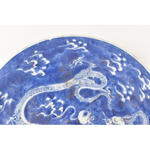 7 - A Chinese blue and white charger, Qing Dynasty, 18th century, painted with two four-clawed dragons s... 