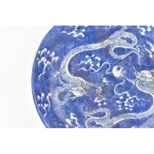 7 - A Chinese blue and white charger, Qing Dynasty, 18th century, painted with two four-clawed dragons s... 