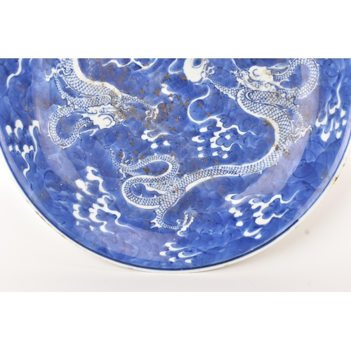 7 - A Chinese blue and white charger, Qing Dynasty, 18th century, painted with two four-clawed dragons s... 