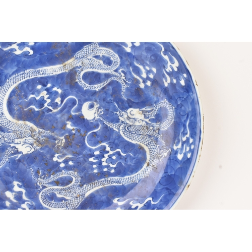 7 - A Chinese blue and white charger, Qing Dynasty, 18th century, painted with two four-clawed dragons s... 
