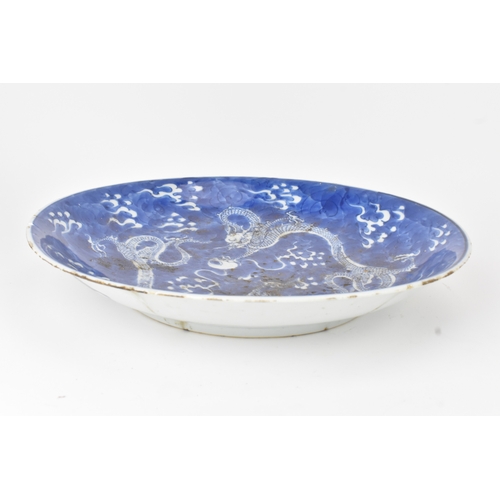 7 - A Chinese blue and white charger, Qing Dynasty, 18th century, painted with two four-clawed dragons s... 