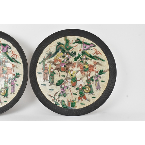 8 - A pair of Chinese famille verte-style crackleware chargers, late Qing dynasty, each painted with war... 