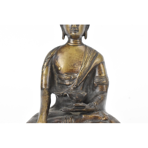 9 - A 19th century bronze figure of Buddha, seated in dhyanasana on a double lotus base, the right hand ... 