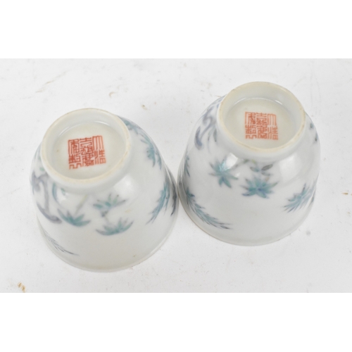 45A - A pair of Chinese famille-verte porcelain cups and saucers, each cup of flared form, decorated with ... 