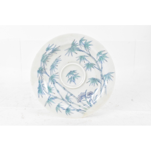 45A - A pair of Chinese famille-verte porcelain cups and saucers, each cup of flared form, decorated with ... 