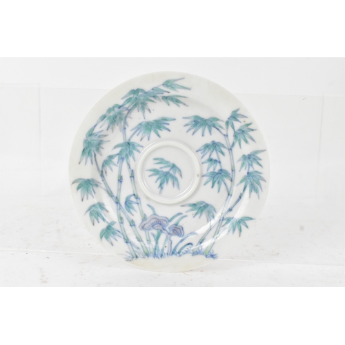 45A - A pair of Chinese famille-verte porcelain cups and saucers, each cup of flared form, decorated with ... 