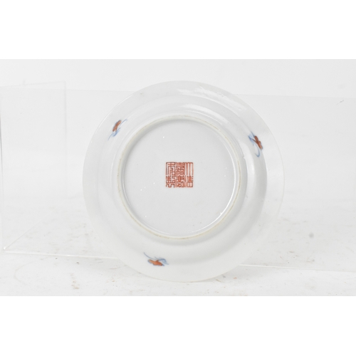 45A - A pair of Chinese famille-verte porcelain cups and saucers, each cup of flared form, decorated with ... 