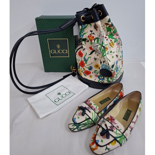 2 - Gucci- A drawstring flora bucket bag having navy leather trim and handles, gold tone hardware, seria... 
