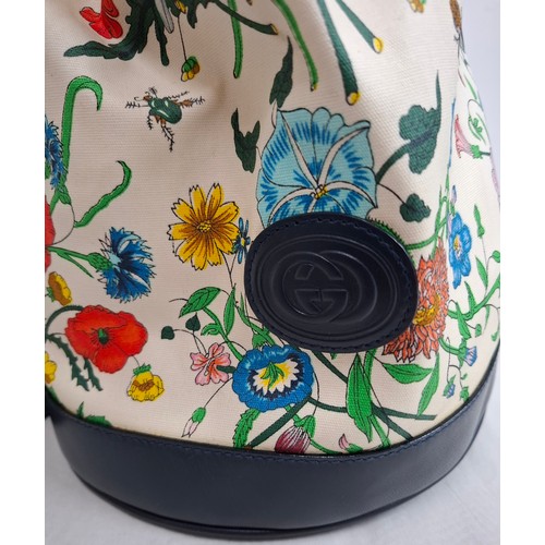 2 - Gucci- A drawstring flora bucket bag having navy leather trim and handles, gold tone hardware, seria... 