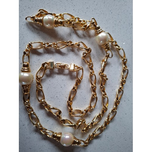3 - Christian Dior- A gold tone curb link necklace with 4 pearlised beads, stamped Chr.Dior© to clasp, a... 