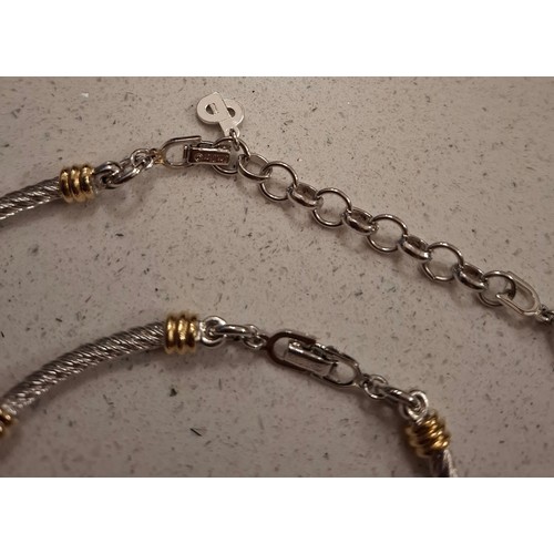 7 - Christian Dior- A two-tone jewellery suite comprising a fancy link necklace, bracelet and hoop clip-... 