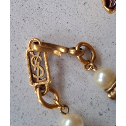 8 - YSL- A late 20th Century gold tone open chain necklace with intermittent faux pearls and aubergine g... 