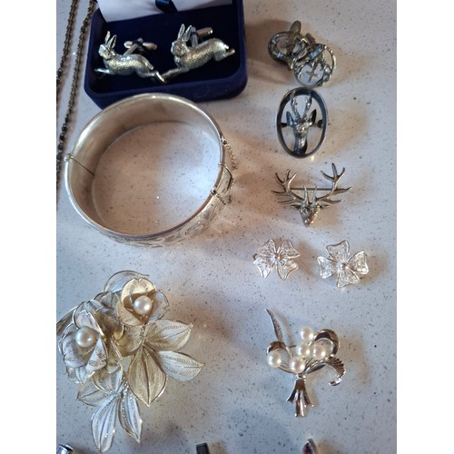 55 - A quantity of silver and silver tone costume jewellery to include an engraved and hinged bangle make... 