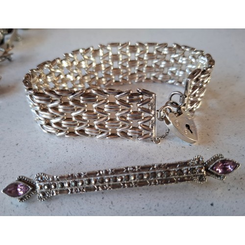 55 - A quantity of silver and silver tone costume jewellery to include an engraved and hinged bangle make... 