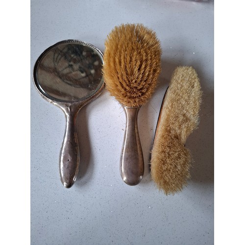 53 - Three matched silver backed dressing table items comprising hand mirror, and 2 brushes, makers mark ... 