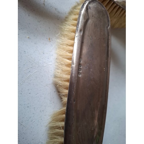 53 - Three matched silver backed dressing table items comprising hand mirror, and 2 brushes, makers mark ... 