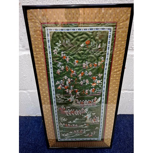 43 - A 20th Century Chinese embroidered panel depicting a festival on water with multiple figures and dra... 