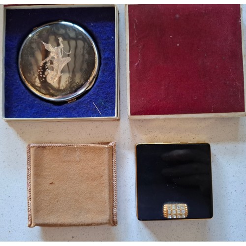 36 - A Sterling silver Niello compact and a Vogue gold tone and black enamel style compact with white gla... 