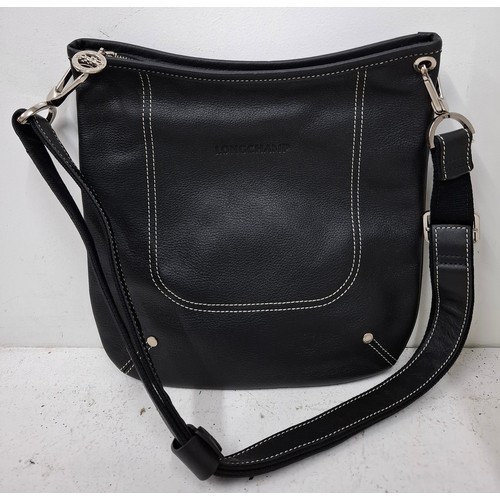 11 - Longchamp- A black leather crossbody bag, 26cm wide x 26cm high, having silver tone hardware, red br... 
